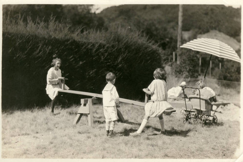 Children playing on the see-saw at the annual Grape Festival at the Kent Family home, circa 1921 [photograph]