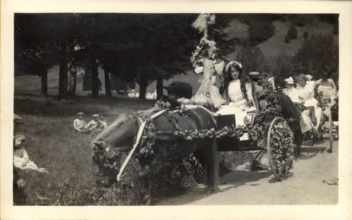 May Queen, twelve-year-old Zeila Heydenfeldt of Larkspur, on her horse drawn float on her way to the second annual May Day celebrations in Kentfield, California, May, 1910 [photograph]