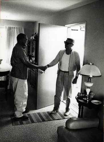 Long-time Marin City resident and community leader Jesse Berry in his new home, with a guest, circa 1963 [photograph]