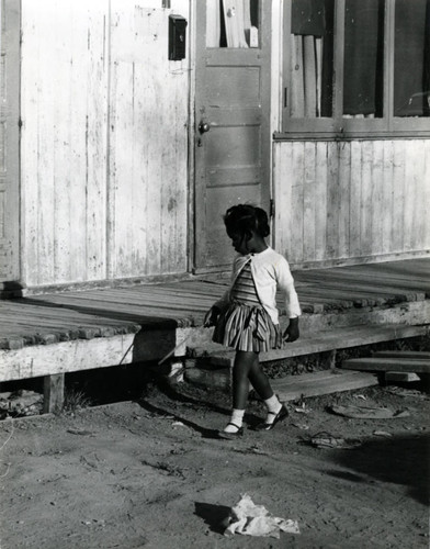 A child in front of World War II-era housing in Marin City, California, circa 1960 [photograph]