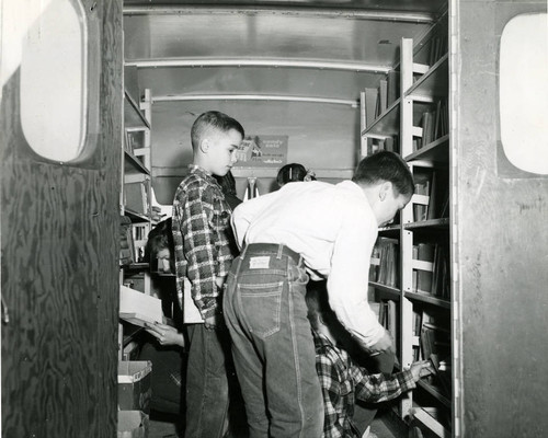 Children select materials from the Marin County Free Library's bookmobile collection, circa 1950 [photograph]