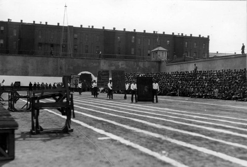 Prisoners parading with handmade posters cheering on their fellow inmates at the San Quentin Little Olympics Field Meet, 1930 [photograph]