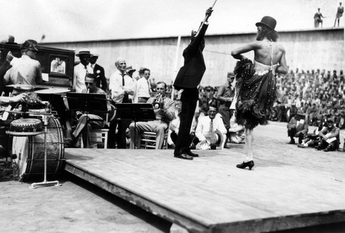 Stage entertainment with musicians and two male dancers (one in female dress), San Quentin Little Olympics Field Meet, 1930 [photograph]