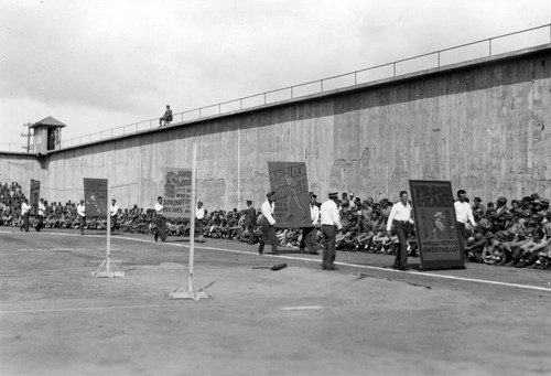 Prisoners parading with handmade posters cheering on their fellow inmates at the San Quentin Little Olympics Field Meet, 1930 [photograph]