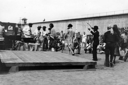 Musicians and male performer in female dress, San Quentin Little Olympics Field Meet, 1930 [photograph]