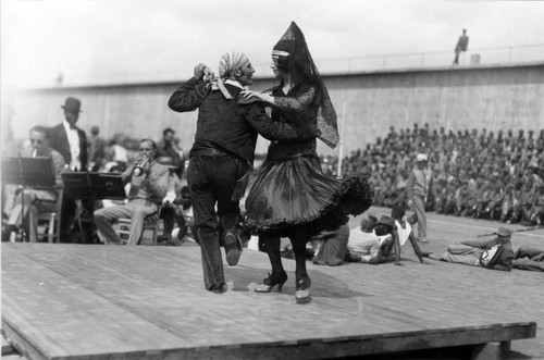 Stage entertainment, featuring two male dancers, one in Spanish female costume, San Quentin Little Olympics Field Meet, 1930 [photograph]