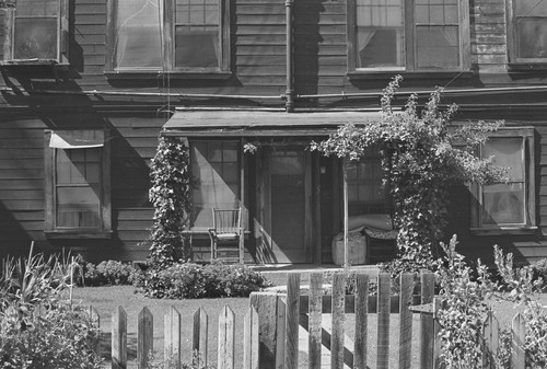 Fenced garden and house with porch, from Walnut Grove