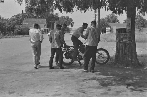 Young men and motorcycle on main street in Monticello, Berryessa Valley