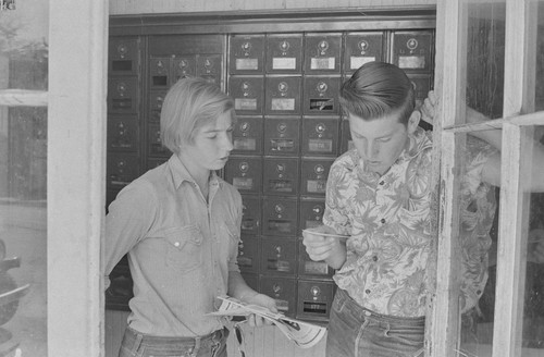 Daughter of rancher Charles Ryan and friend reading mail at Post Office, Monticello, Berryessa Valley