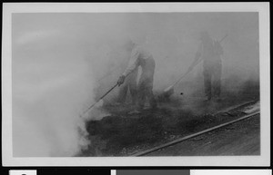 Men working in thick smoke during road construction