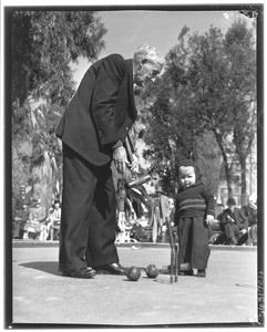 An old man and young boy playing croquet