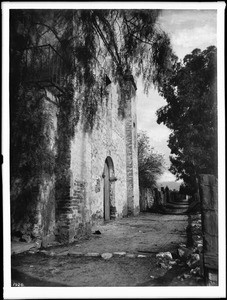 East front of Mission San Gabriel with entrance to cemetery, ca.1900