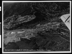 Aerial view of flooded area of Verdugo Wash, showing damaged bridge, Glendale, 1938