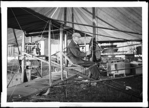 Aviator Charles F. Willard at the controls of his Curtiss biplane at the Dominguez Hills Air Meet, 1910