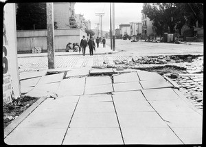 Golden Gate refugees eating next to a sunk street on Sixteenth and Howard Street, San Francisco, 1906