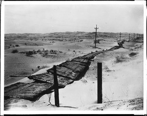 Plank roads and iron telephone poles stretching across the sand dunes between the Colorado River and the Imperial Valley, ca.1920