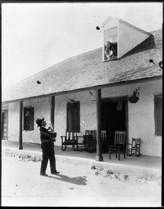 Abram Ontivares serenading his wife Petra outside of the Ontivares adobe, ca.1925