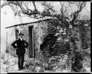 Man standing next to the brick building of the salt works north of Redondo Beach, ca.1901(?)