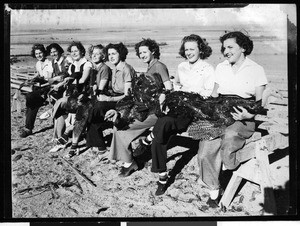 Women sitting on a bench holding turkeys