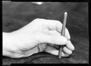 Close-up view of a hand bronzing a stick of material