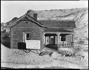 Exterior view of "The Bottle House" a house made of bottles in Rhyolite, Nevada, ca.1925