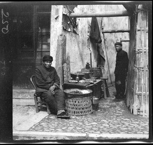 Water chestnut vendor on the curbside in China, ca.1900