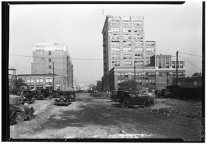 View of a dirt road in the city, where several automobiles are parked