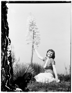 Woman sitting next to an agave plant