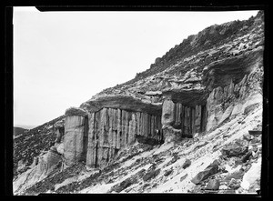 Sloping rock formation with a man standing at the foot of cliffs, Red Rock Canyon