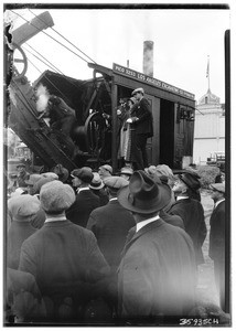 Large crowd, mostly composed of men, standing around a piece of machinery in action at the Los Angeles Excavating Co