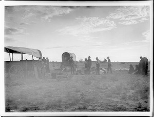 Group of about a dozen Hopi Indians making camp at night in the Hopi village of Shonguapavi, ca.1900