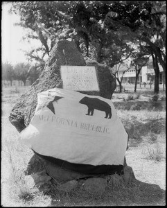 The Bear Flag draped and tied around the rock with the S.V.W.C. Bear Flag Monument Plaque, Sonoma, ca.1915