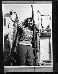 Portrait of a woman holding up a tuna fish