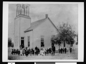 Group portrait of the students of the Cahuenga Valley Township School posed in front of the school with a horse, ca.1884