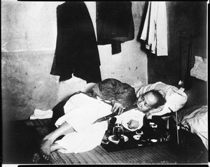 Portrait of a Chinese opium smoker on his mat in the Barbary Coast of San Francisco, ca.1910-1920