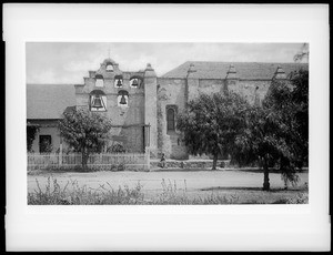 Mission San Gabriel, California, showing bell tower with pepper trees, ca.1884