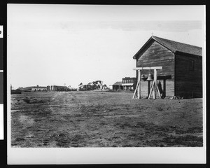 Old mission bells near several buildings in San Diego, ca.1886