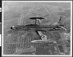 Lockheed Starfire in flight over a city, ca.1949-1959