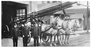 Los Angeles firefighters posing in front of a horse-drawn water cannon at the Los Angeles Fire Department, ca.1913