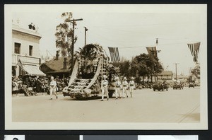 Parade with a float and marchers, ca.1920