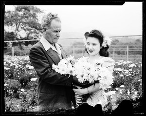 A woman (Susanne Hill?) and Mr. Becker (Decker?) holding Marconi daisies on Susanne Hill (?)