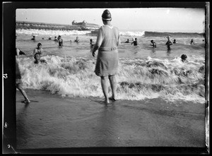 Woman standing on a beach, looking towards the ocean, Long Beach