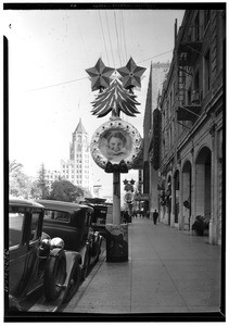 Metallic wreath with portrait on Hollywood Boulevard, showing Hollywood First National Bank in background