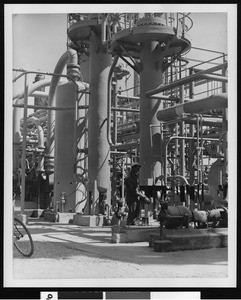 Exterior view of the Shell Oil Company, showing a painter at work, ca.1940