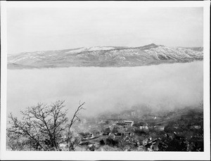 The town of Ashland, Oregon, below the clouds and showing Grizzly Peak above the clouds