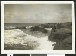 Surf breaking across rock formations and cliffs