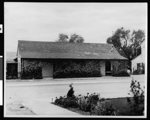 Exterior view of the home of Don Domingo(Miguel?) Yorba, shown from across a paved street two miles south of San Juan Capistrano, ca.1930