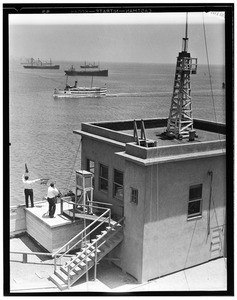 Rooftop view of the Marine Exchange, showing men signaling to ship, ca.1920-1929