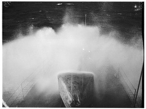 Birdseye view of a large ship traversing heavy seas