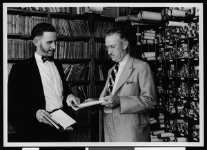 Interior view of Department of Public Works, Harbor District Office, showing two men near rows of blueprints